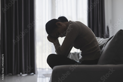 Suffer from depression , mental health problem. asian young woman sitting on the sofa feeling depressed. Women are stressed and depressed.