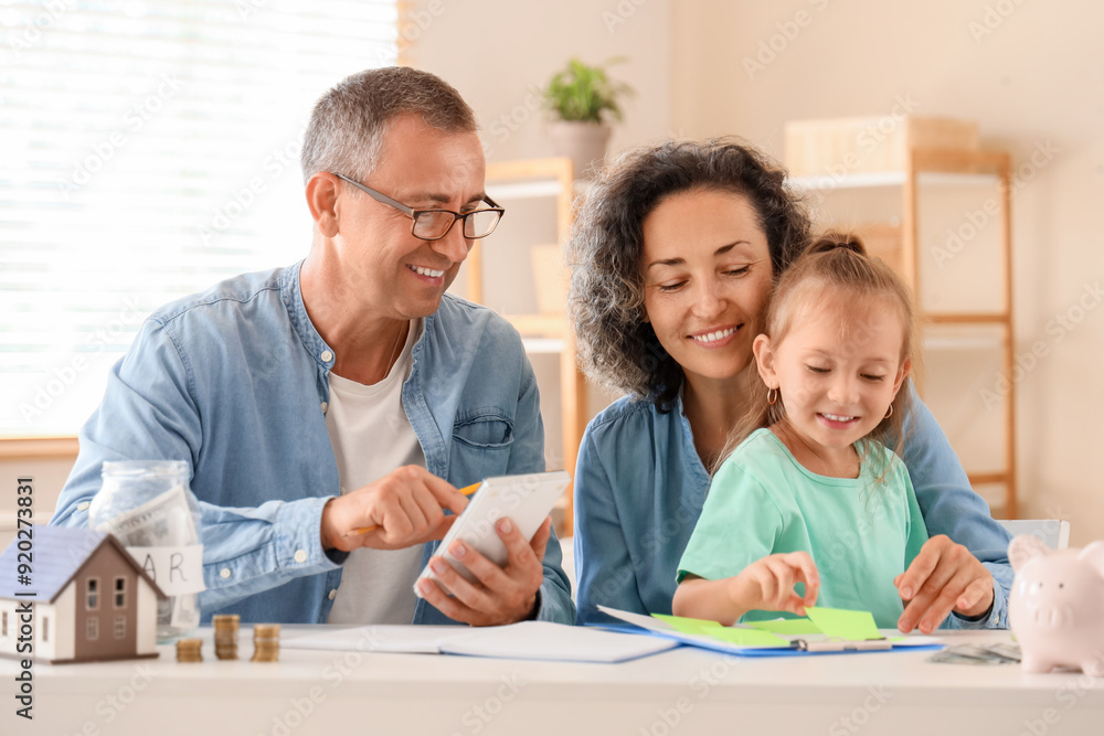 Happy family with piggy bank and calculator at home Happy family with piggy bank and calculator at home