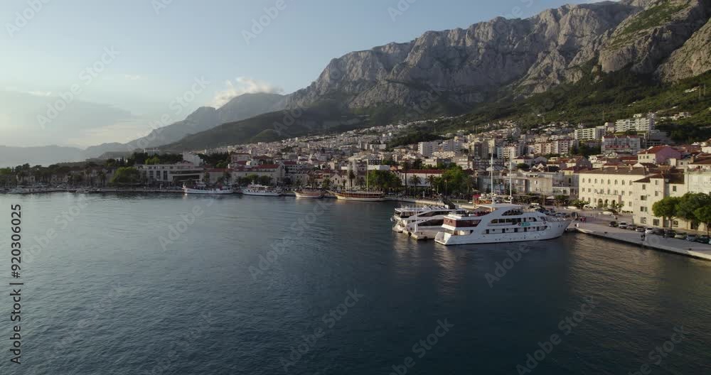 Boats docked on the marina of Makarska, Croatia during sunset in summer, aerial Boats docked on the marina of Makarska, Croatia during sunset in summer, aerial