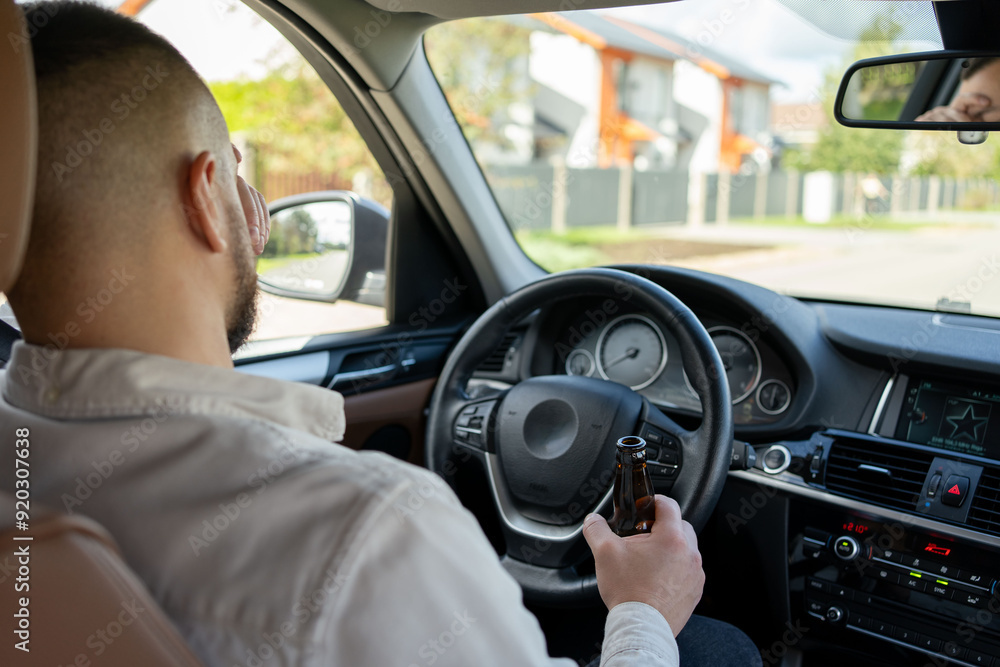 man drinking alcohol while driving the car. Don't drink and drive concept man drinking alcohol while driving the car. Don't drink and drive concept