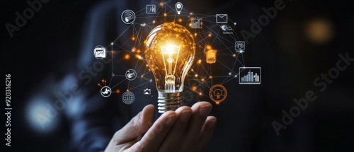 A hand holds a glowing light bulb with a network of icons and lines surrounding it, representing the power of innovation and connectivity.