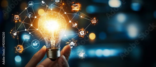 A hand holds a light bulb with a network of glowing icons surrounding it, representing new ideas and innovation.