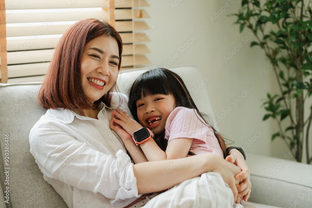 A woman and a child are sitting on a couch, the woman is smiling A woman and a child are sitting on a couch, the woman is smiling
