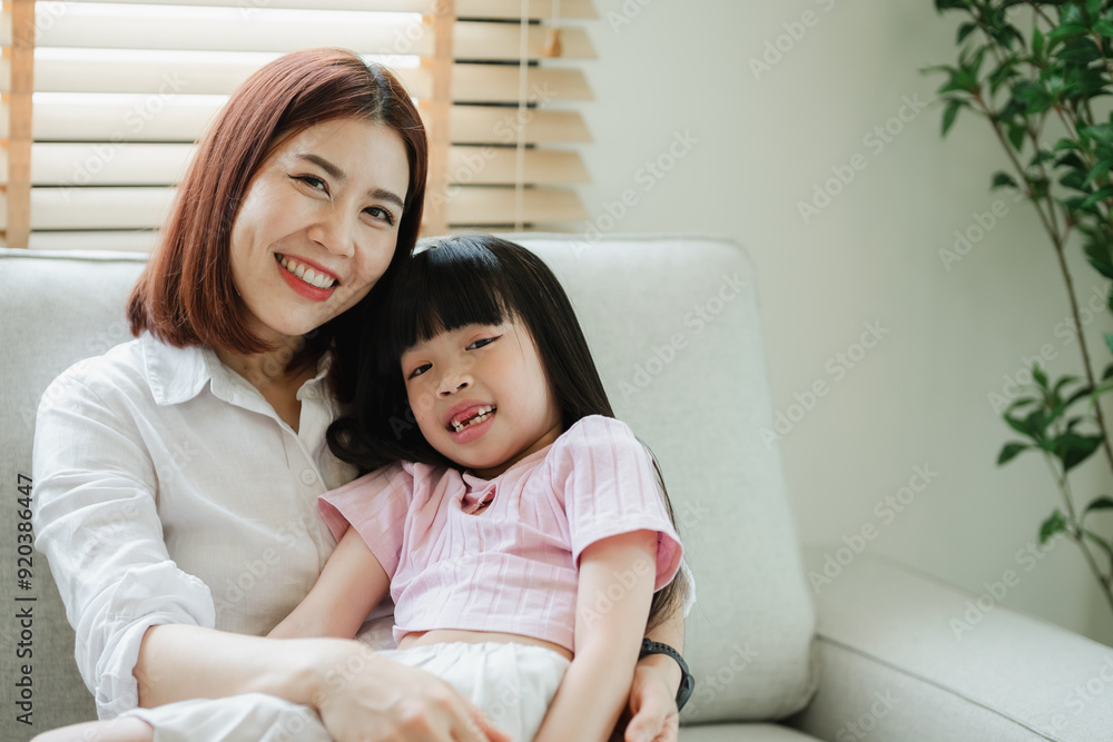 A woman and a child are sitting on a couch A woman and a child are sitting on a couch