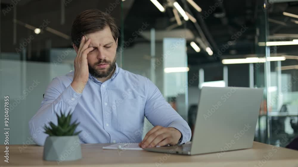 Tired businessman experiencing headache or fatigue at his office desk. Concept of stress, burnout, workplace problems. Tired businessman experiencing headache or fatigue at his office desk. Concept of stress, burnout, workplace problems.