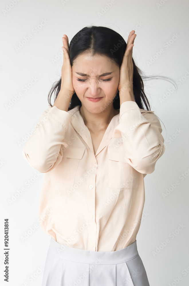Unhappy and upset Asian woman covering her ear, having a problem with loud noise, noise pollution, loud noise problem Unhappy and upset Asian woman covering her ear, having a problem with loud noise, noise pollution, loud noise problem