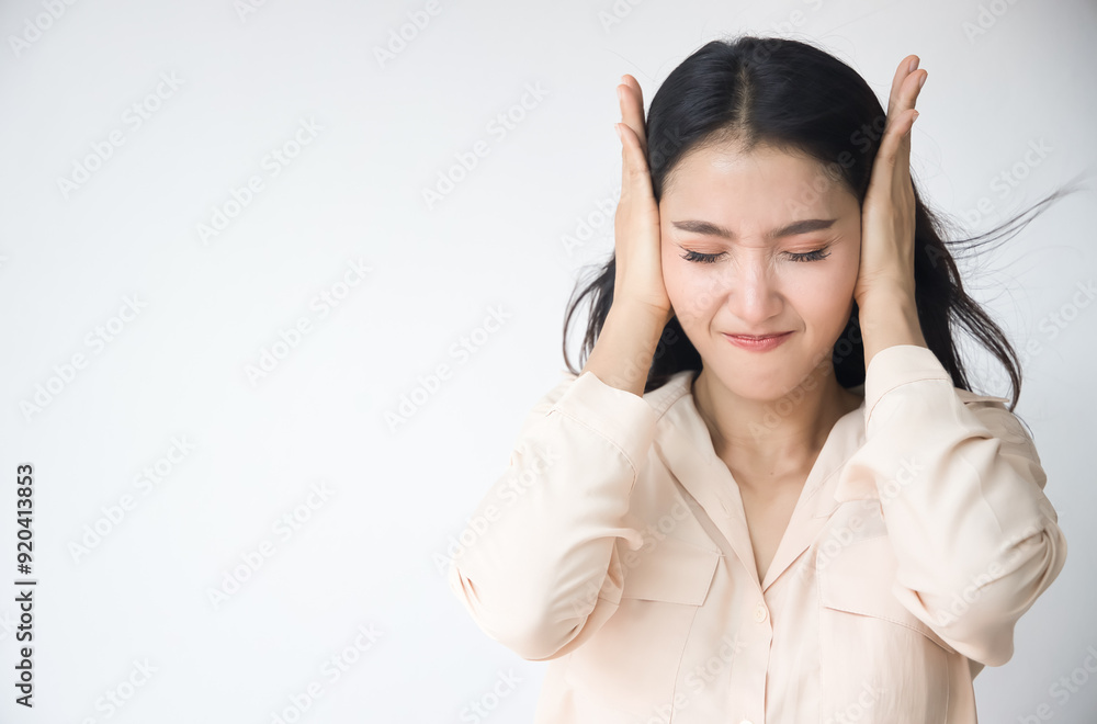 Unhappy and upset Asian woman covering her ear, having a problem with loud noise, noise pollution, loud noise problem Unhappy and upset Asian woman covering her ear, having a problem with loud noise, noise pollution, loud noise problem