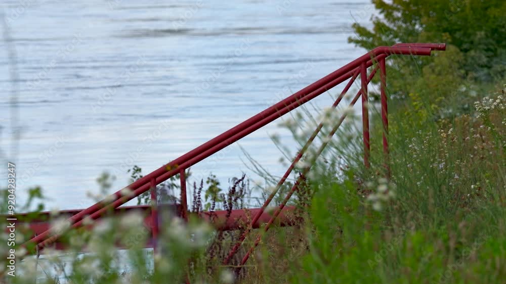 Red metal staircase leading to a river dock on the Danube river Red metal staircase leading to a river dock on the Danube river