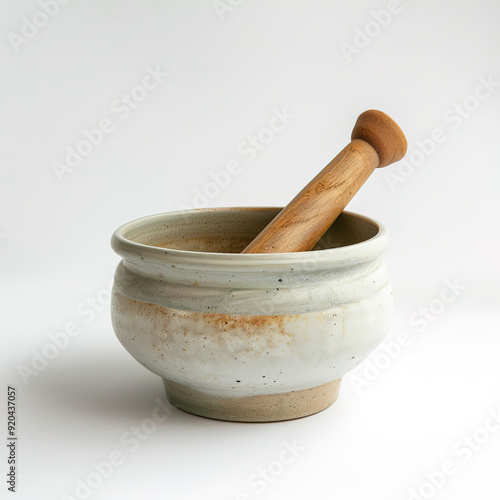 Ceramic mortar and pestle lying on a surface, showcasing a traditional kitchen tool used for grinding and mixing ingredients in culinary practices.

 photo