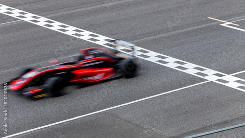 Fotografía Motion blur race car racing on speed track, Car race on the international circuit race track crossing start and finish line, Race car crossing start and finish line, Target business achieve victory