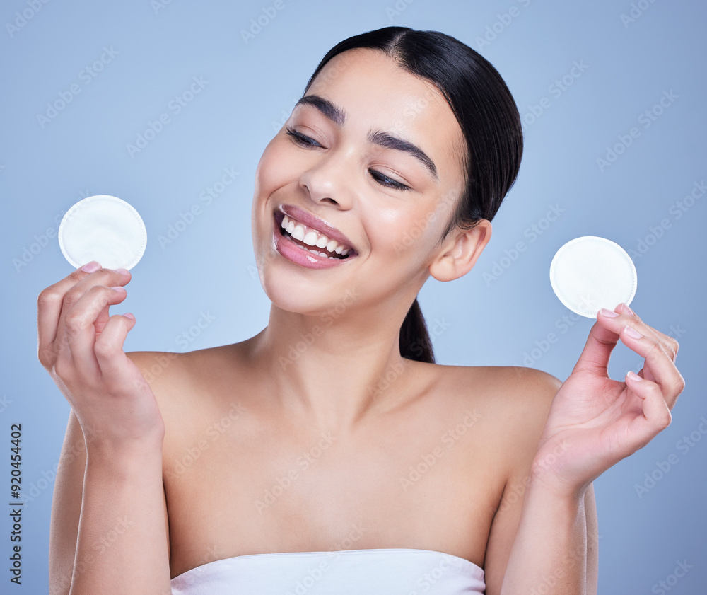 Cotton pad, cleanse and woman with skincare in studio with natural, health and facial routine for hygiene. Beauty, glow and person with dermatology treatment with cosmetic product by blue background. Cotton pad, cleanse and woman with skincare in studio with natural, health and facial routine for hygiene. Beauty, glow and person with dermatology treatment with cosmetic product by blue background.