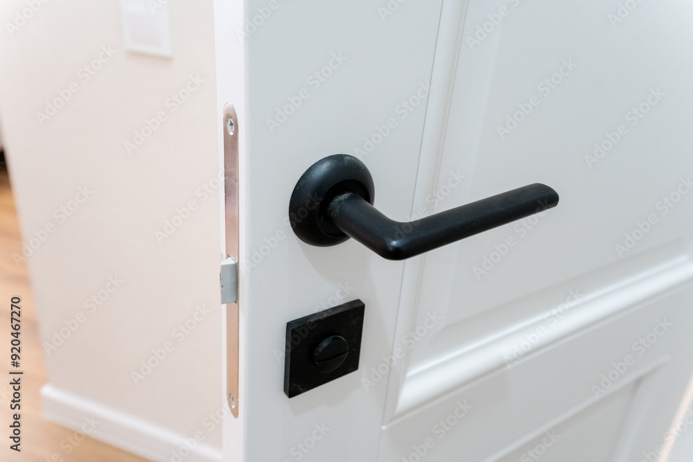A close up of a white door with a black door handle A close up of a white door with a black door handle