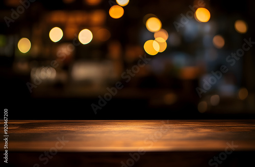 Empty wood table top on blur light gold bokeh of cafe restaurant in dark background photo