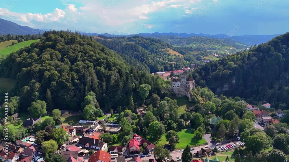 Aerial view of a castle surrounded by green hills built on a cliff in the Carpathian mountains, near Bran, Transylvania Aerial view of a castle surrounded by green hills built on a cliff in the Carpathian mountains, near Bran, Transylvania