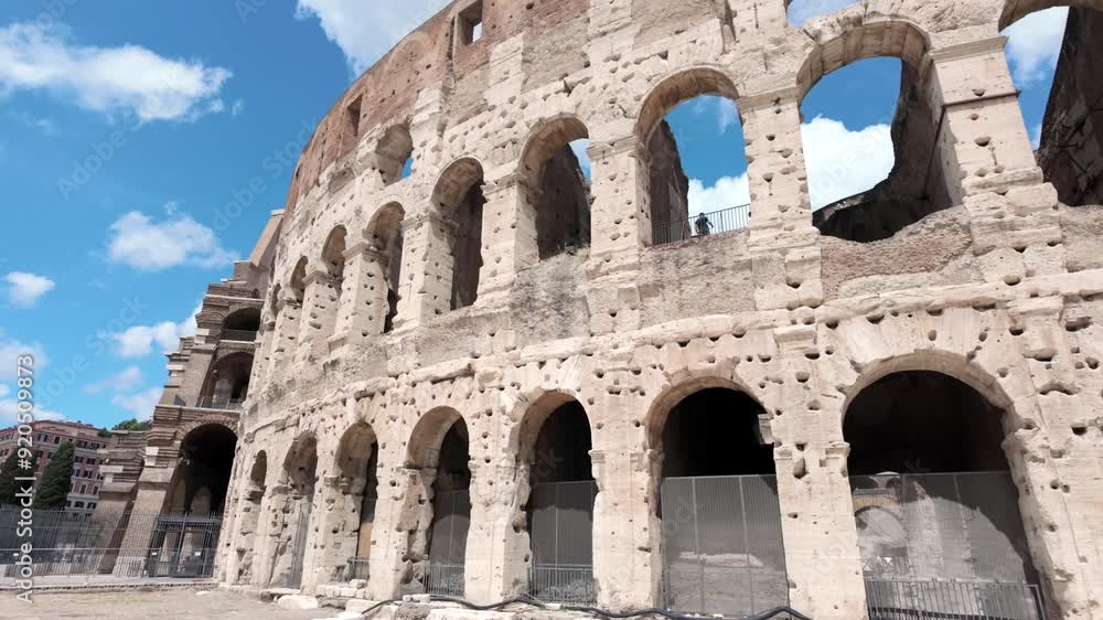 Clouds and blue sky seen through arches of historical Colosseum in Rome Clouds and blue sky seen through arches of historical Colosseum in Rome