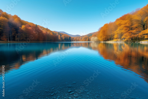 A large lake surrounded by autumn mountains with colorful foliage