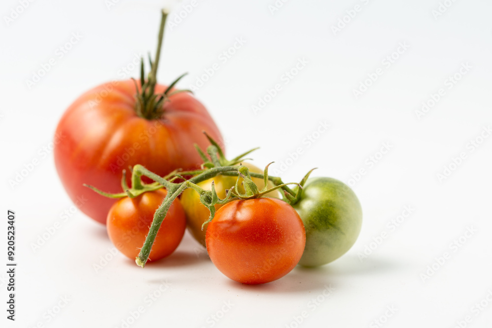 Ripe and green natural tomatoes on a white background. Close up. Ripe and green natural tomatoes on a white background. Close up.