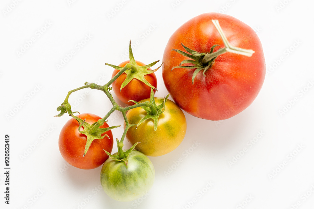 Ripe and green natural tomatoes on a white background. Close up. Ripe and green natural tomatoes on a white background. Close up.