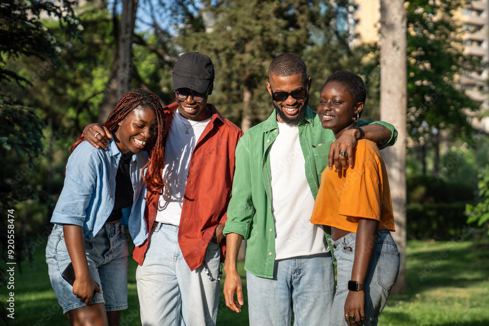 Young black students company of friends spending time together, chilling walking in sunny park. Carefree African American guys and girls stand together in pairs laughing and embracing. Friendship Young black students company of friends spending time together, chilling walking in sunny park. Carefree African American guys and girls stand together in pairs laughing and embracing. Friendship