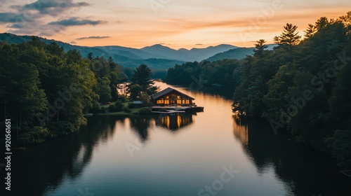 A cabin is on a lake surrounded by trees. The cabin is wooden and has a porch. The lake is calm and peaceful.