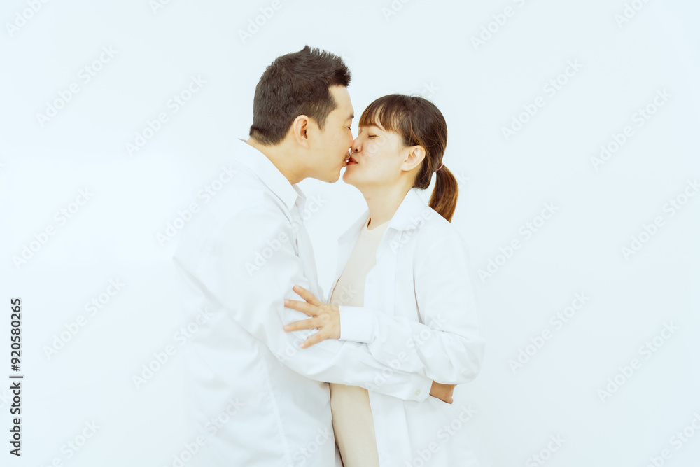 A middle-aged Asian couple, with the woman being pregnant, shares a loving embrace, smiling with happiness and anticipation for their soon-to-arrive baby, symbolizing family togetherness and joy. A middle-aged Asian couple, with the woman being pregnant, shares a loving embrace, smiling with happiness and anticipation for their soon-to-arrive baby, symbolizing family togetherness and joy.