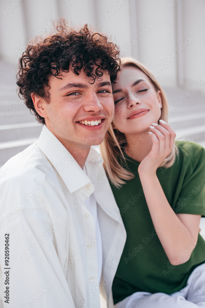 Smiling beautiful woman and her handsome boyfriend. Couple in casual summer clothes. Happy cheerful family. Female and man having fun. They posing in the street in sunny day. Sit at stairs Smiling beautiful woman and her handsome boyfriend. Couple in casual summer clothes. Happy cheerful family. Female and man having fun. They posing in the street in sunny day. Sit at stairs