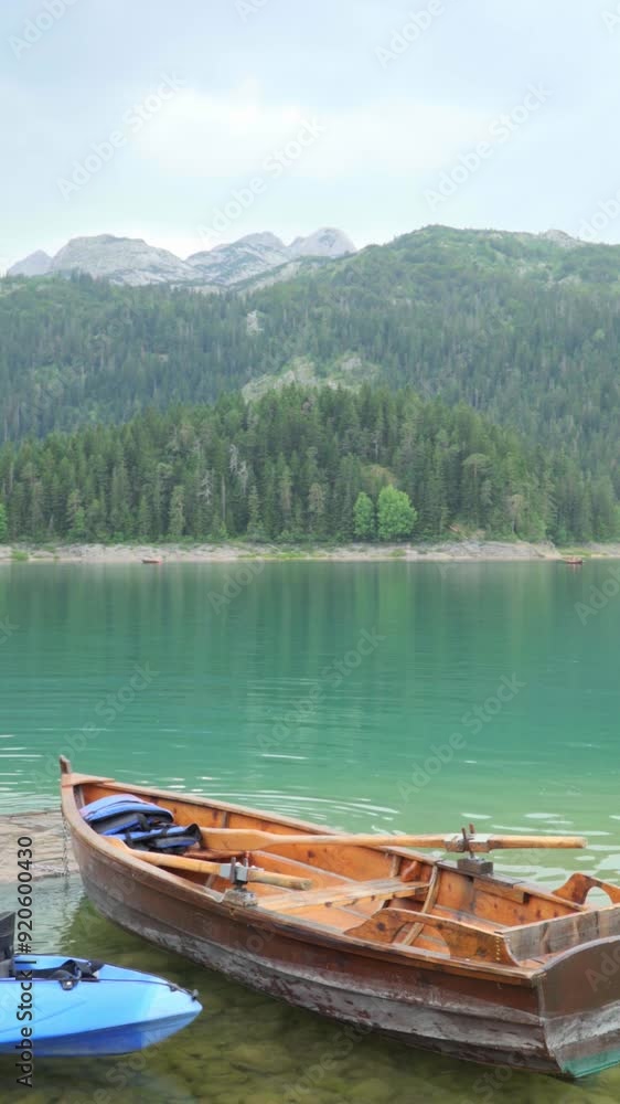 Durmitor National Park, Montenegro. View of the rowing boat on the background of the Black lake (Crno jezero) in the mountains Durmitor National Park, Montenegro. View of the rowing boat on the background of the Black lake (Crno jezero) in the mountains