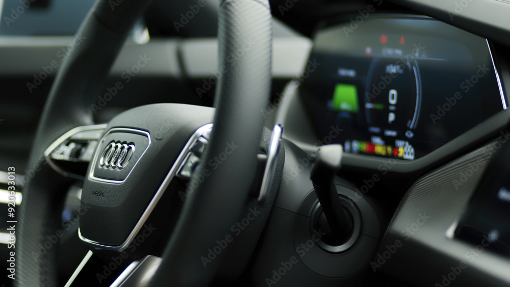 Close-up of a steering wheel in a modern electric car, featuring a sleek dashboard and advanced technology. Ideal for illustrating the elegance and innovation in today’s automotive industry. Close-up of a steering wheel in a modern electric car, featuring a sleek dashboard and advanced technology. Ideal for illustrating the elegance and innovation in today’s automotive industry.