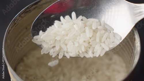 Raw Asian White Rice (Oryza sativa); Close Up Overhead Focus Shot Of A Spoon Scooping Uncooked, Dry, Rice. A Common Staple. photo