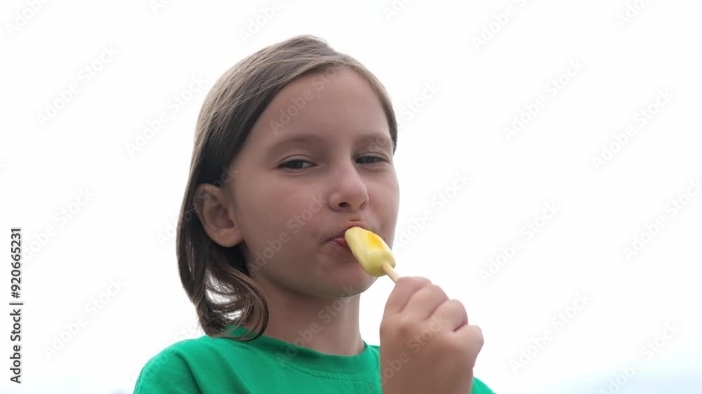 Child eats ice cream in summer when outside on sunny summer day. Sweet food on hot summer days. Bright light, colorful ice cream. Child eats ice cream in summer when outside on sunny summer day. Sweet food on hot summer days. Bright light, colorful ice cream.