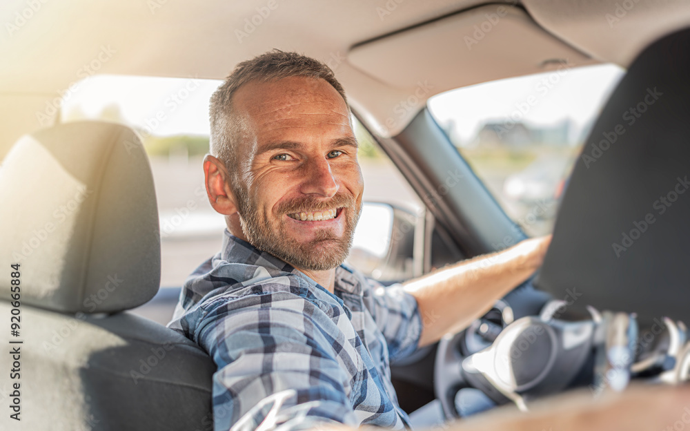 The driver is a young attractive man driving a white car.