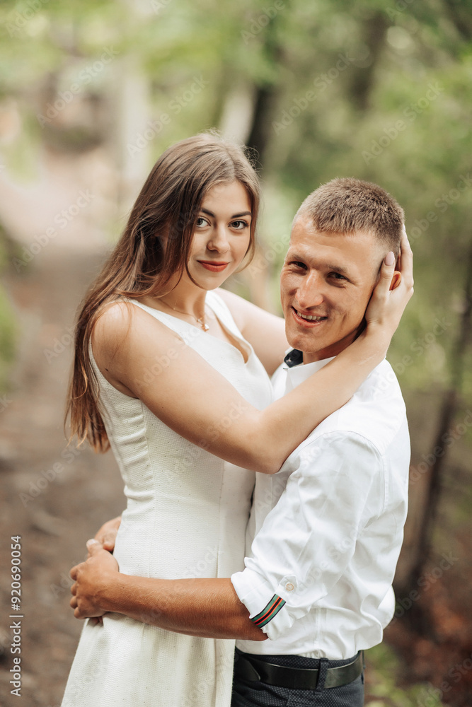 A young couple is embracing each other in a forest A young couple is embracing each other in a forest