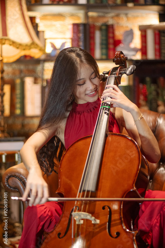 Obraz na płótnie Asain musician playing the Cello in beautiful room. w salonie