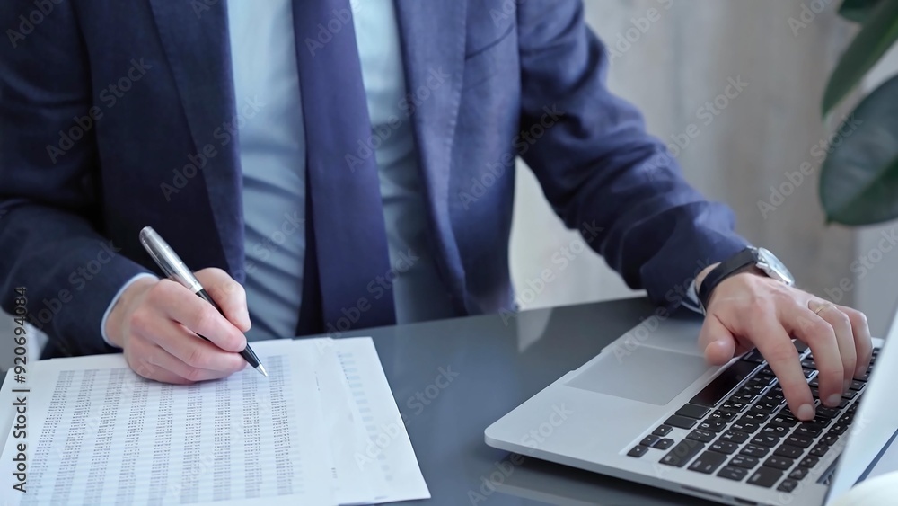 Businessman analyzing financial data on laptop and calculator. Close-up of a professional auditor working on financial reports. Business concept Businessman analyzing financial data on laptop and calculator. Close-up of a professional auditor working on financial reports. Business concept