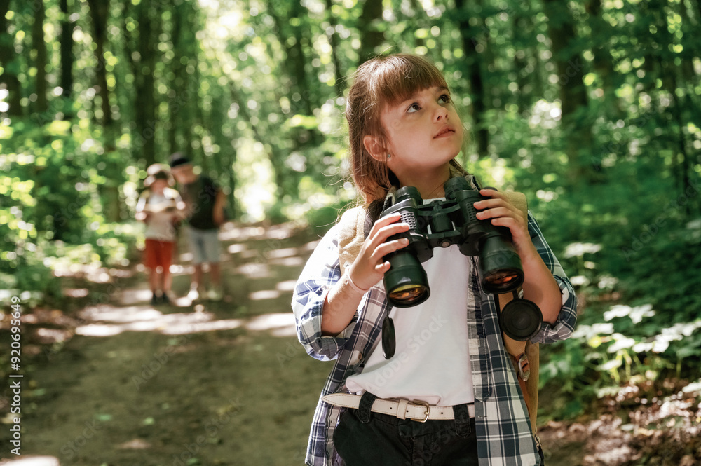 Binoculars in hands. Kids in forest at summer daytime together Binoculars in hands. Kids in forest at summer daytime together