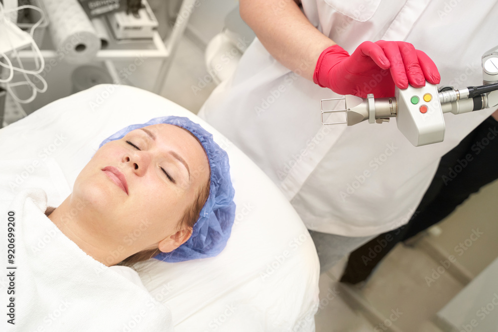 Face procedure. Professional dermatologist uses modern technology for laser hair removal, or neoplasms. Lady undergoes a rejuvenating treatment, enhancing skin health in a well-equipped beauty clinic Face procedure. Professional dermatologist uses modern technology for laser hair removal, or neoplasms. Lady undergoes a rejuvenating treatment, enhancing skin health in a well-equipped beauty clinic