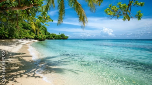 A serene tropical beach featuring crystal clear waters, soft white sand, and overhanging palm tree shadows, set under a bright blue sky with a few scattered clouds.