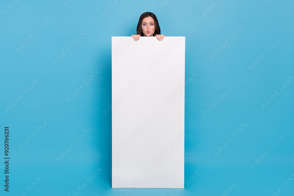 Full length photo of amazed funky lady hide over cellphone poster banner design nomad isolated blue color background