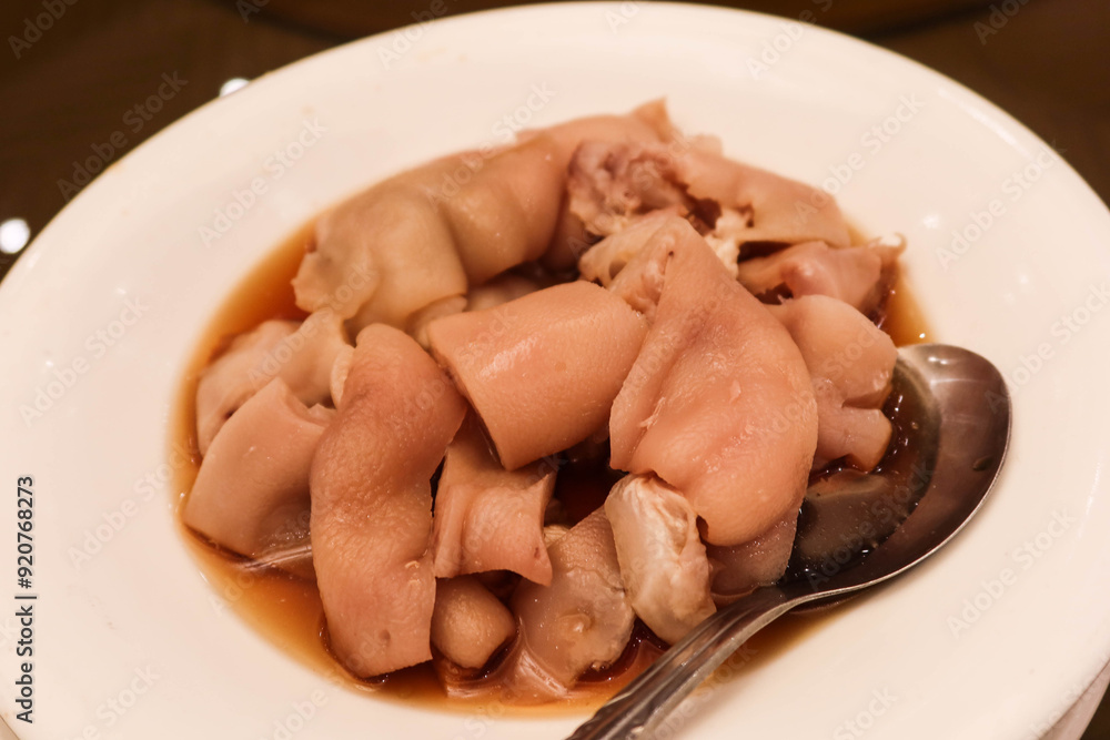close up of Shanghai Style Chinese Deboned Drunken Pork Knuckle on a white plate with a spoon close up of Shanghai Style Chinese Deboned Drunken Pork Knuckle on a white plate with a spoon