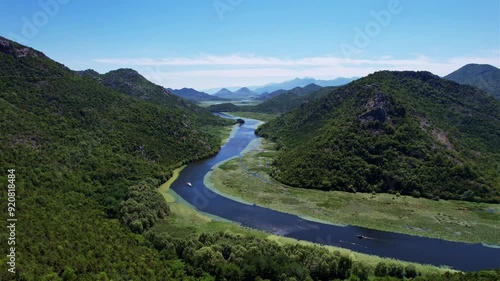 Drone view of the river in the middle of green hills mountains. Rjeka Crnojevica Montenegro. Aerial view photo