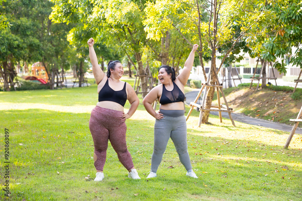 Obraz premium exercising outdoor in park. beautiful young chubby overweight woman in sportswear doing exercise outdoors at park. fitness sport club, body and health care. Activity