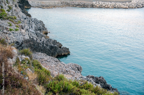 Breakwater next to the rocky coast at sunset. photo