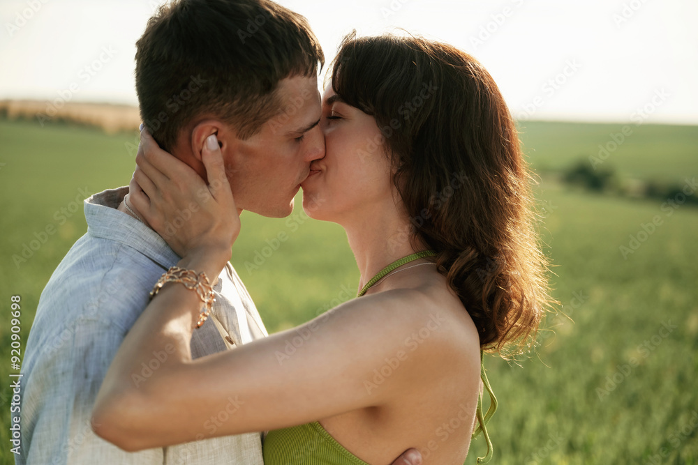 Kissing each other. Lovely couple are on the agricultural field together Kissing each other. Lovely couple are on the agricultural field together