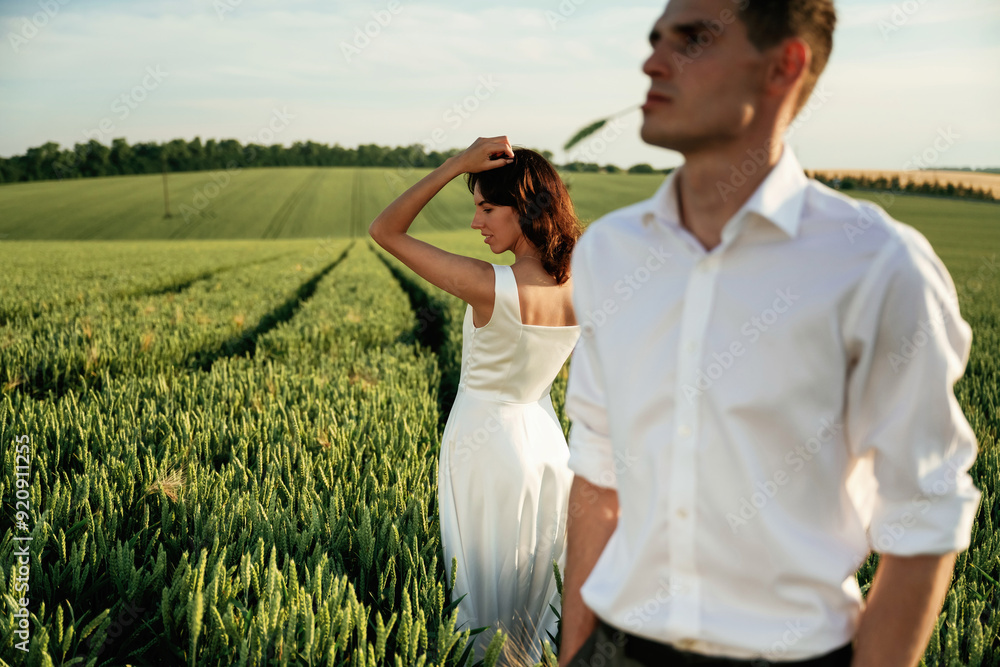 Fototapeta premium Wedding clothes. Lovely couple are on the agricultural field together