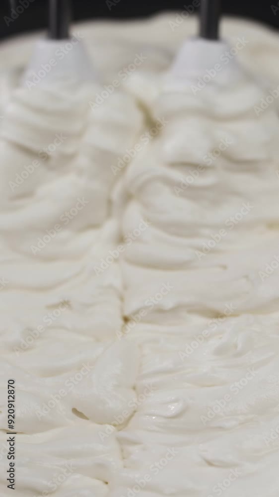 The delicious white buttercream is whipped with a mixer. Macro The delicious white buttercream is whipped with a mixer. Macro