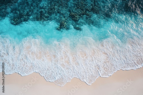 Turquoise waves crash onto the soft white sand, creating a stunning contrast on the pristine beach in TobOS under a clear blue sky