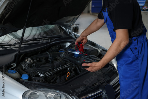 Auto mechanic fixing car at automobile repair shop, closeup