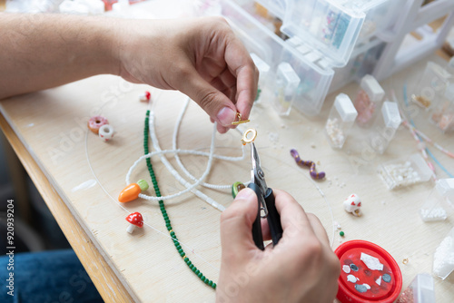 Obraz na plátně A creative man is engaged in beadwork
