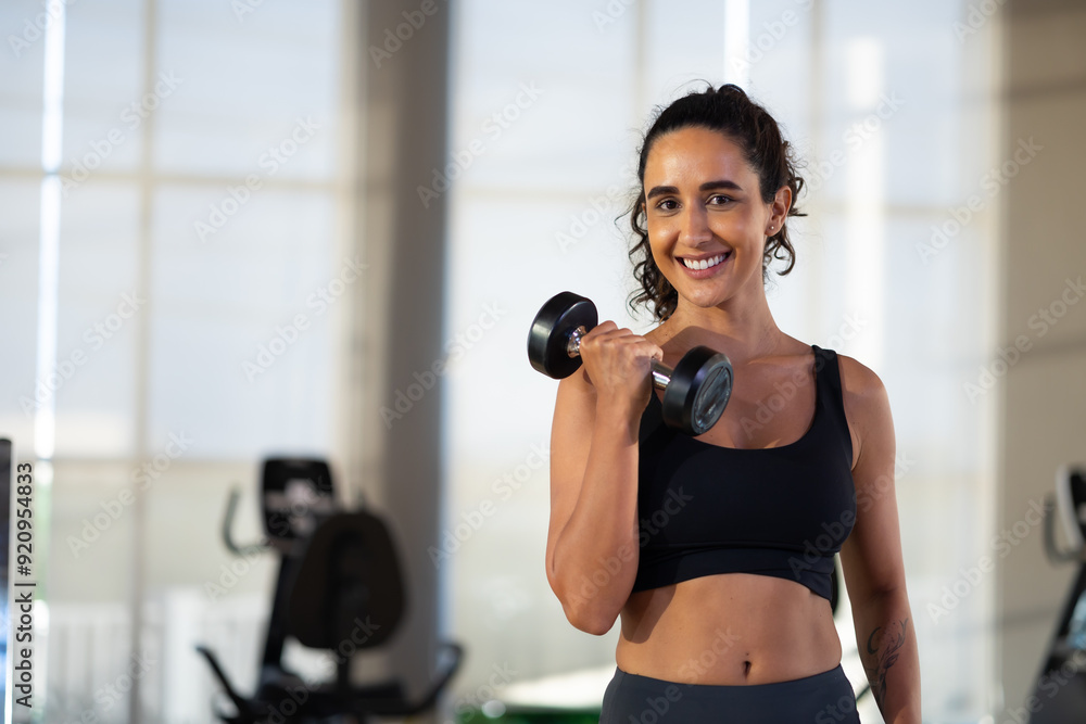 portrait femal lifting dumbbells at gym. beautiful young hispanic woman wearing sporty fitness clothes doing exercise indoors at gym fitness sport club, body and health care portrait femal lifting dumbbells at gym. beautiful young hispanic woman wearing sporty fitness clothes doing exercise indoors at gym fitness sport club, body and health care