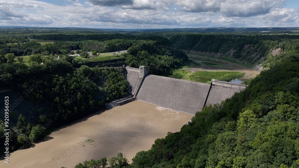 Mt Morris Dam in New York State on Genesse River at Letchworth State Park with blue sky and clouds in a beautiful countryside landscape with green trees in summer season Mt Morris Dam in New York State on Genesse River at Letchworth State Park with blue sky and clouds in a beautiful countryside landscape with green trees in summer season